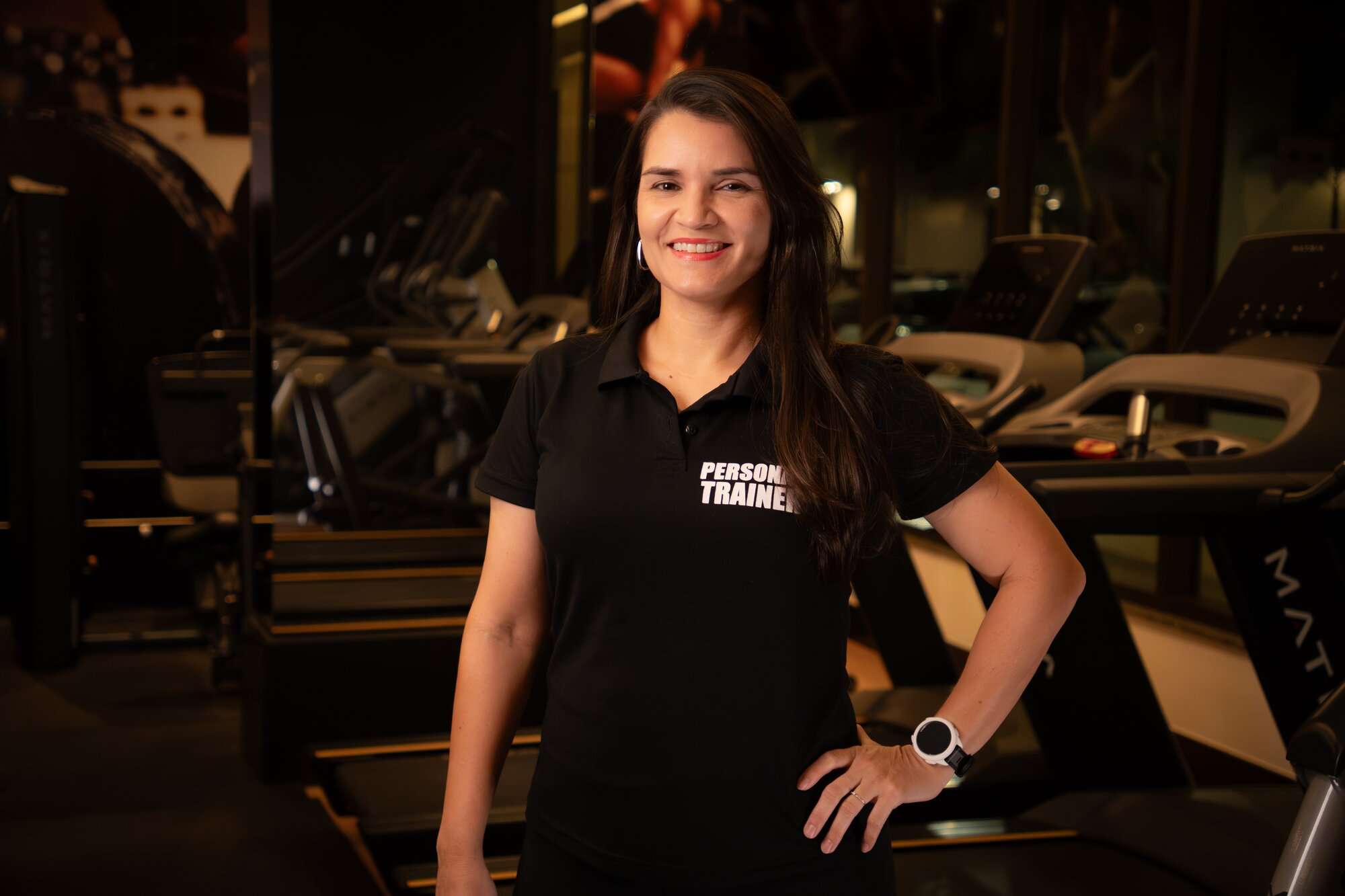 Licia Furtado, personal trainer presencial, sorrindo na academia em Brasília